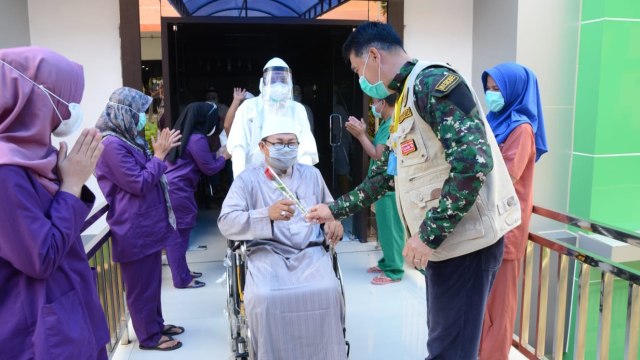 Wali Kota Jambi, Syarif Fasha saat menyambut pasien sembuh COVID-19 Kota Jambi dengan memberi setangkai Mawar. Foto: Jambikita.id