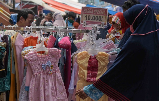 Seorang ibu memilih baju untuk putrinya di pasar Baru kota Bekasi, Jawa Barat, Sabtu (23/5). Foto: ANTARA FOTO/Paramayuda