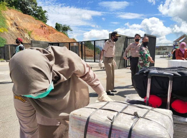 Petugas Karantina Pertanian Entikong saat memeriksa barang bawaan WNI, pemeriksaan dilakukan untuk memastikan tidak ada produk pertanian yang dibawa