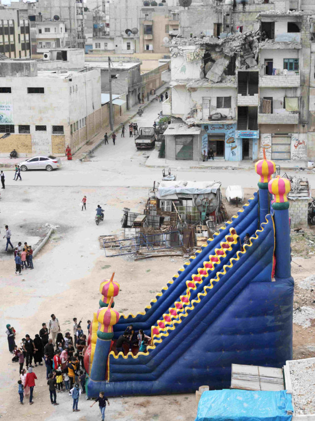 Foto udara saat anak-anak bermain di taman hiburan darurat untuk merayakan liburan Idul Fitri,di kota Idlib, Suriah. Foto: REUTERS / Khalil Ashawi