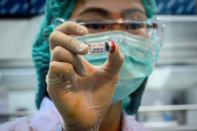 Peneliti memegang kandidat vaksin virus corona yang siap di uji coba kepada monyet di Pusat Penelitian Primata Thailand Universitas Chulalongkorn. Foto: AFP/Mladen ANTONOV