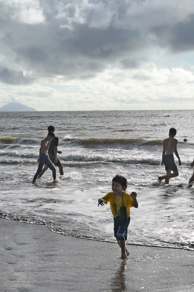 Seorang wisatawan menikmati liburan di pantai Sambolo, Anyer, Banten, Selasa (26/5). Foto: ANTARA FOTO/Asep Fathulrahman