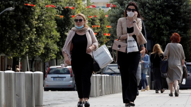 Perempuan berjalan mengenakan masker. Foto: REUTERS/Stevo Vasiljevic