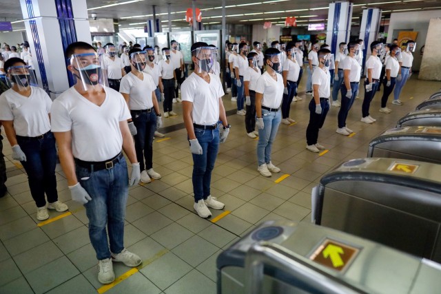 Polisi menggunakan alat pelindung diri menjaga jarak sosial selama simulasi dalam persiapan beroperasinya kembali LRT di Manila, Filipina.  Foto: REUTERS/Eloisa Lopez