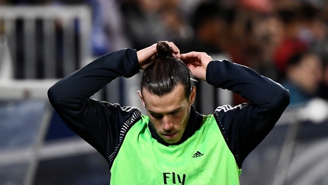 Gareth Bale melakukan pemanasan di bangku cadangan Real Madrid. Foto: Pierre-Philippe Marcou/AFP