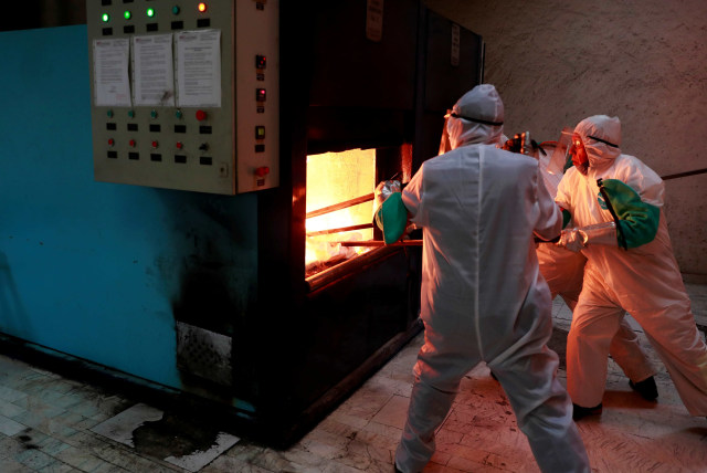 Karyawan krematorium bekerja di depan oven kremasi di krematorium San Isidro, Meksiko. Foto: REUTERS/Carlos Jasso
