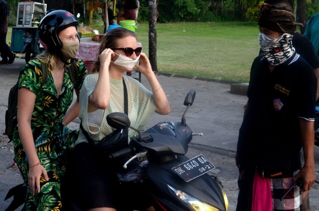 Pecalang atau petugas keamanan adat Bali melakukan pengawasan terkait pencegahan virus corona. Foto: Antara/Fikri Yusuf