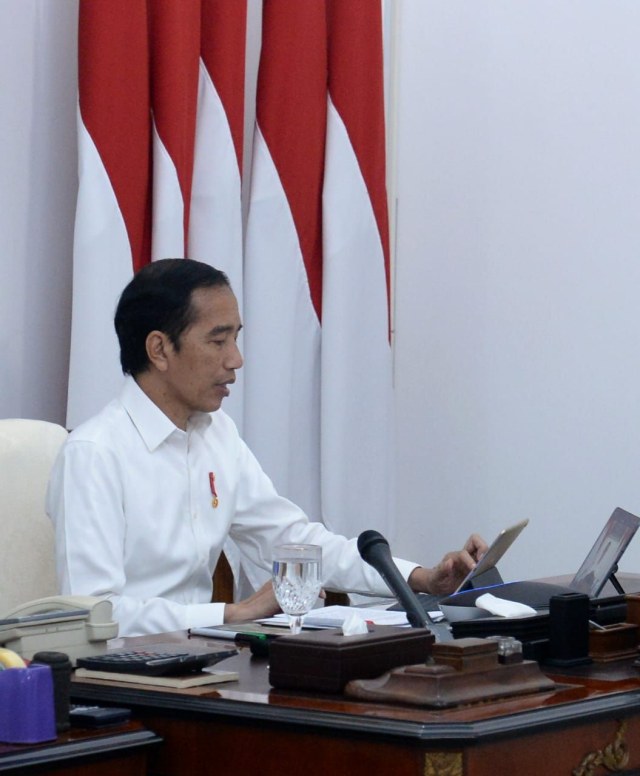 Presiden Joko Widodo memimpin rapat terbatas (ratas) untuk membahas percepatan penanganan pandemi Covid-19 secara telekonferensi dari Istana Merdeka. Foto: BPMI Setpres/Kris