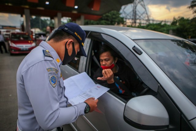 Petugas memeriksa kendaraan di gerbang tol Cikupa, Kabupaten Tangerang, Banten, Rabu (27/5). Foto: ANTARA FOTO/Fauzan