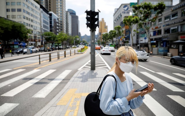 Seorang wanita mengenakan masker saat beraktivitas di Seoul, Korea Selatan, Kamis (28/5). Foto: REUTERS/Kim Hong-Ji