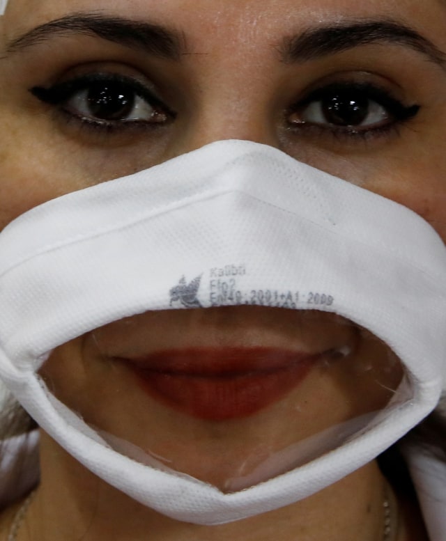Pekerja menggunakan masker transparan yang dirancang untuk warga tunarungu di Istanbul, Turki (27/5). Foto: REUTERS/Umit Bektas