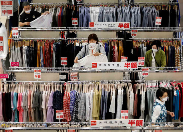 Pengunjung memakai masker ketika memilih pakaian di dalam pusat perbelanjaan Aeon di Chiba, Jepang. Foto: Reuters/KIM KYUNG-HOON