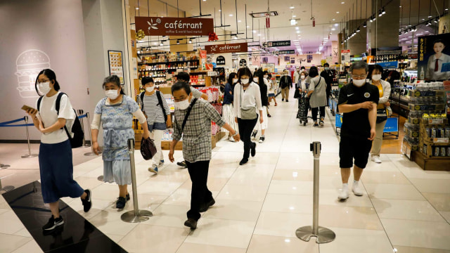 Para pengunjung memakai masker di dalam pusat perbelanjaan Aeon di Chiba, Jepang. Foto: Reuters/KIM KYUNG-HOON