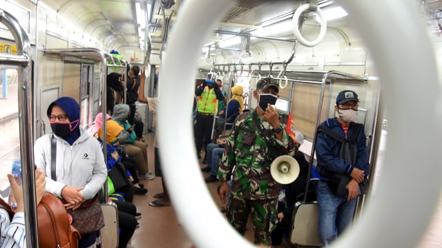 Aparat TNI membantu mendisiplinkan jarak penumpang KRL Commuterline sesuai protokol kesehatan pencegahan COVID-19, Kamis (28/5). Foto: ANTARA/Indrianto Eko Suwarso