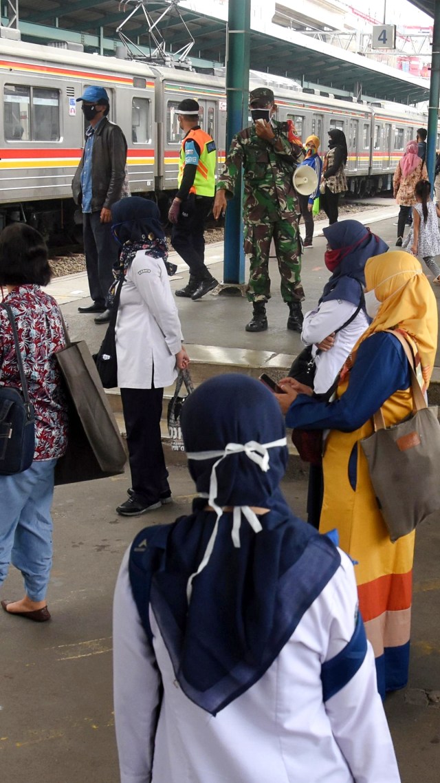 Petugas memberikan imbauan pendisiplinan protokol kesehatan pencegahan COVID-19 kepada penumpang KRL di Stasiun Manggarai, Jakarta, Kamis (28/5). Foto: ANTARA FOTO/Indrianto Eko Suwarso