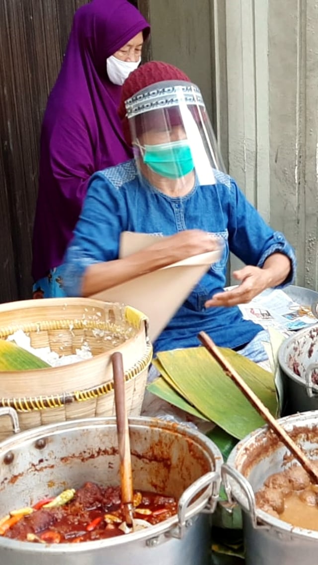 Sudarmi, pedagang gudeg di Jalan Urip Sumoharjo, Kota Yogyakarta, mengenakan face shield serta masker ketika melayani pembeli. Foto: Arfiansyah Panji/kumparan