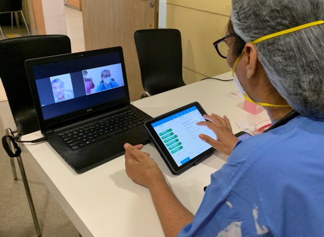 Dokter di India memeriksa pasien secara online.