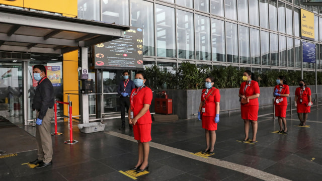 Anggota staf Air Asia mengantre untuk memasuki Bandara Internasional Netaji Subhas Chandra Bose, ketika penerbangan domestik kembali dibuka, di Kolkata, India. Foto: REUTERS/Rupak De Chowdhuri