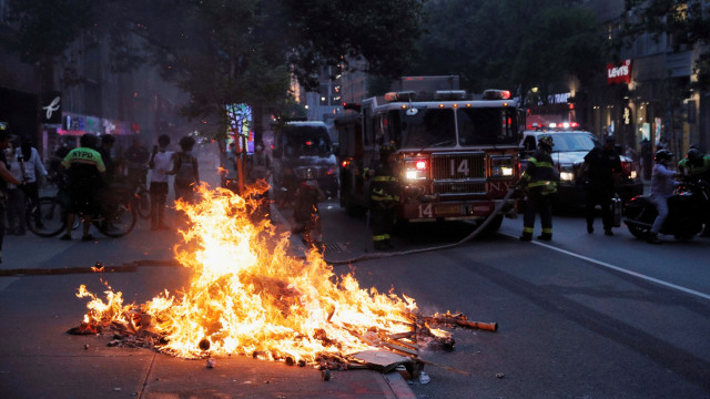 Aparat bersiap untuk memadamkan api akibat kerusuhan pada aksi protes atas kematian George Floyd oleh polisi Minneapolis, di Manhattan, New York, AS. Foto: REUTERS/Andrew Kelly