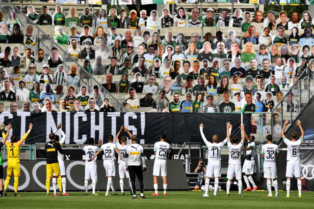 Borussia Moenchengladbach memberikan penghormatan kepada suporter mereka yang tidak bisa hadir menyaksikan laga di Borussia Park. Foto: Martin Meissner / POOL / AFP