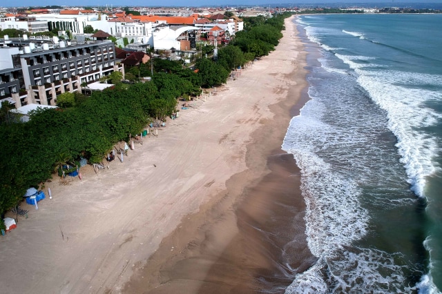 Suasana kawasan wisata Pantai Kuta yang ditutup sementara tampak lengang di Badung, Bali. Foto: ANTARA FOTO/Fikri Yusuf