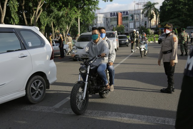 Pemotor melintasi razia masker di Banda Aceh. Foto: Abdul Hadi/acehkini 