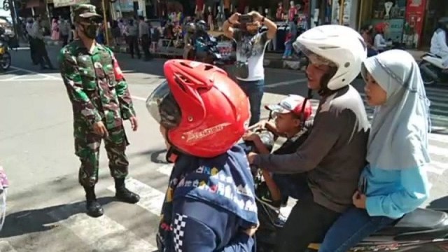 Anggota TNI menghentikan pengendara yang tidak memakai masker saat diberlakukan "new normal" di Jalan Ahmad Yani, Kabupaten Garut, Jawa Barat. Foto: ANTARA/Feri Purnama