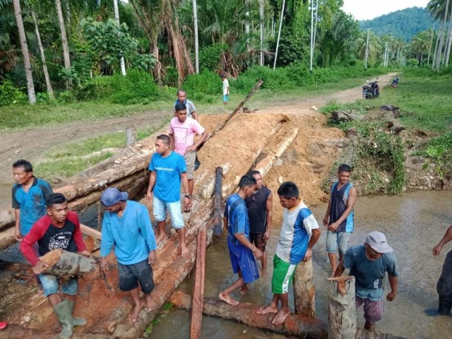 Warga empat Desa di Mangoli Tengah, Kepulauan Sula, Maluku Utara, gotongroyong membangun kembali jembatan yang rusak. Foto: Hartati Paningfat