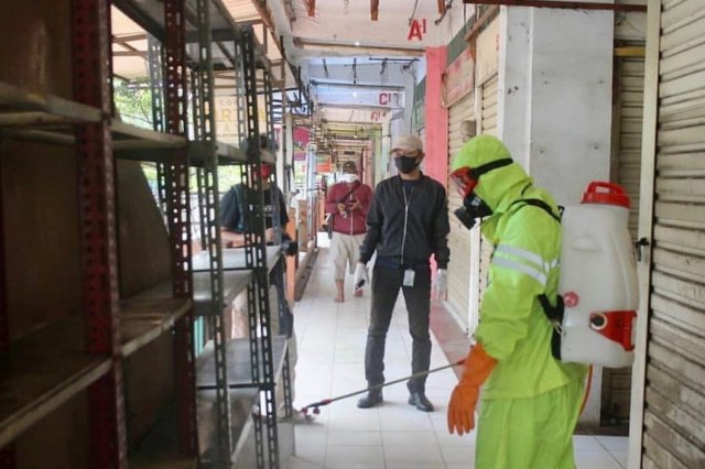 Petugas menyemprotkan cairan disinfektan di lokasi Pasar Cileungsi yang tutup sementara.  Foto: Dok. Pemkab Bogor