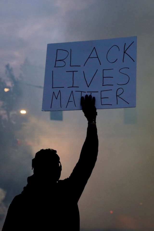 Seorang demonstran memegang papan bertuliskan 'Black Lives Matter' saat aksi demo berlangsung di Seattle, Washington, AS, Senin (1/6). Foto: REUTERS/Lindsey Wasson