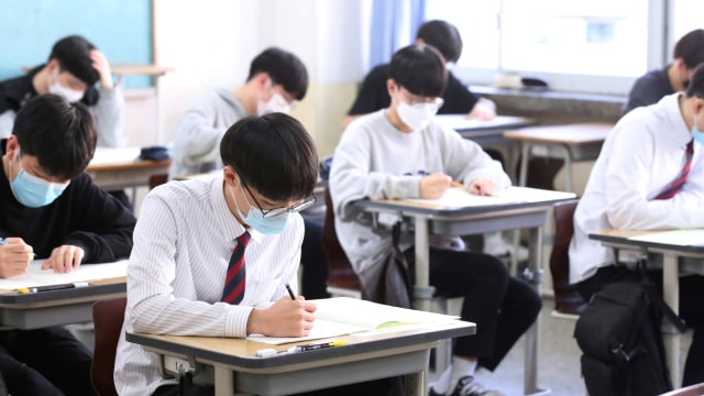 Siswa sekolah menengah yang mengenakan masker sat  mengikuti ujian di Seoul, Korea Selatan. Foto: Reuters