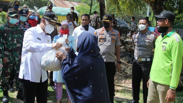 Walikota Kendari, Ir Sulkarnain menyerahkan bantuan paket sembako kepada warga. Foto: Dok Pemkot Kendari.