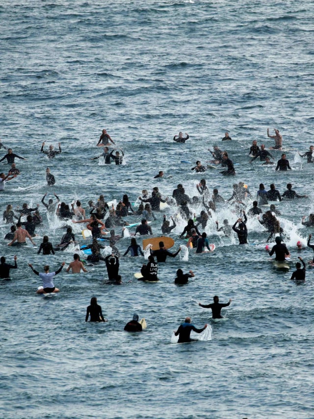 Ratusan peselancar mengikuti aksi Paddle out for Unity di Moonlight Beach Encinitas, California. Foto: REUTERS/Mike Blake