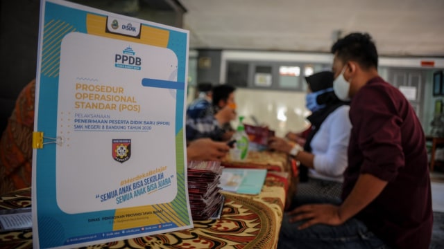 Sejumlah orang tua calon peserta didik mencari informasi terkait penerimaan peserta didik baru (PPDB) di SMKN 8, Bandung, Jawa Barat, Kamis (4/6). Foto: ANTARA FOTO/Raisan Al Farisi