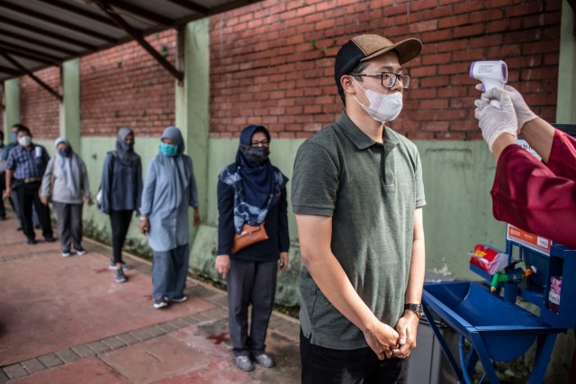 Wisatawan melakukan pengukuran suhu tubuh saat berlangsungnya simulasi normal baru di TMII, Jakarta, Kamis (4/6). Foto: ANTARA FOTO/Aprillio Akbar