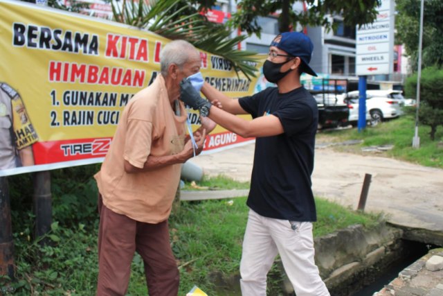 Tim Urban Id di Palembang memberikan masker kepada seorang pengumpul barang bekas di Jalan Basuki Rahmat. (Foto. Dok Urban Id)