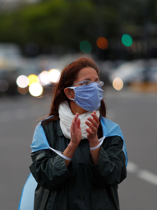 Seorang warga menggunakan masker saat mengikuti unjuk rasa anti-karantina di Buenos Aires, Argentina. Foto: REUTERS / Agustin Marcarian