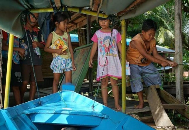 Anak-anak bantaran sungai saat melepas sebuah perahu yang dijadikan sebagai perahu buku.(FOTO: Perahu Buku untuk InfoPBUN) 