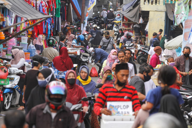 Sejumlah warga dan pengendara motor memadati kawasan sebuah pasar di Indonesia, saat pandemi COVID-19 berlangsung. Senin (18/5/2020). Foto: Antara/Arif Firmansyah
