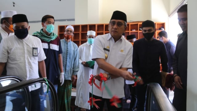 Gubernur Sulbar, Ali Baal Masdar, menggunting pita menandai penggunaan eskalator di Masjid Raya Suada Mamuju. Foto: Dok. Kominfo Sulbar