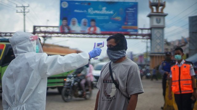 Pemeriksaan suhu tubuh bagi warga Palembang untuk mencegah penyebaran COVID-19. (foto: Ary Priyanto/Urban Id)