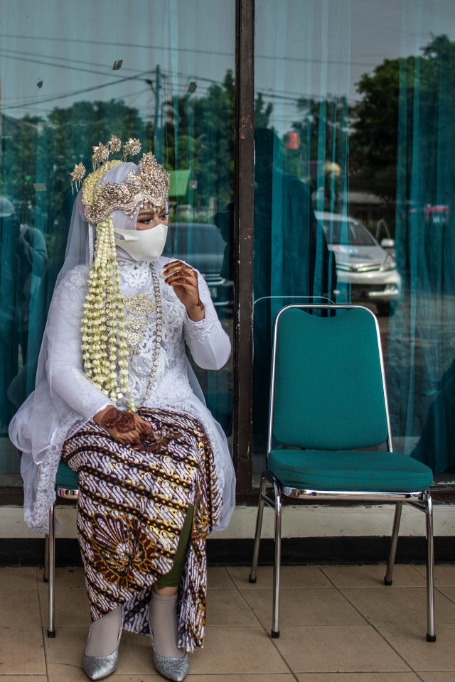 Calon pengantin wanaita menggunakan masker saat menunggu giliran untuk mengikuti prosesi akad nikah di KUA Ciracas, Jakarta, Sabtu (6/6). Foto: ANTARA FOTO/Aprillio Akbar