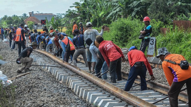 Ilustrasi sejumlah pekerja memasang bantalan rel baru di jalur perlintasan kereta api. Foto: Antara/Adeng Bustomi