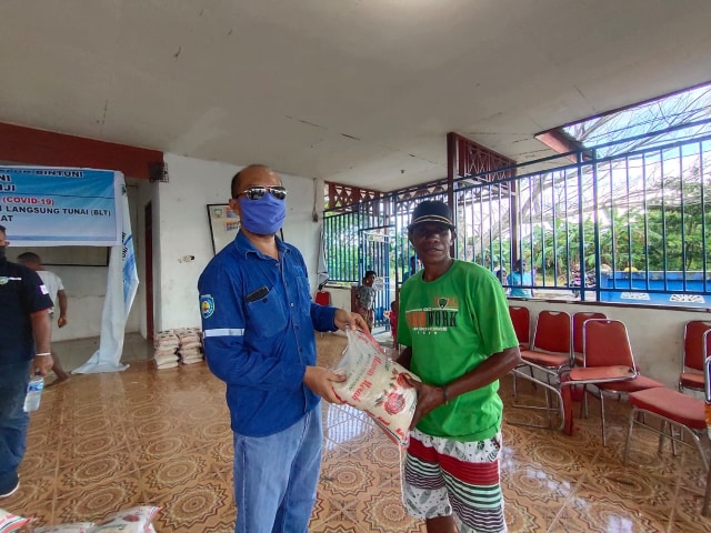 Perwakilan Petrotekno Technical School, Ferianto, saat menyerahkan bantuan beras secara langsung kepada warga Teluk Bintuni. Foto: Istimewa