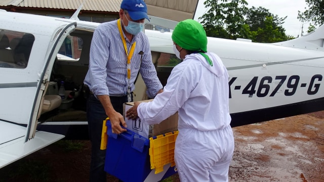 Bakteriolog Diana Carolina Galvan memberikan sampel tes corona kepada pilot sekaligus pemilik pesawat pribadi Ernesto Perez sebelum penerbangan. Foto: Reuters/LUIS JAIME ACOSTA