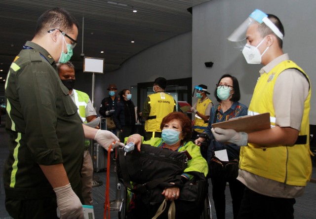 Petugas melakukan pemeriksaan kesehatan penumpang yang baru saja mendarat dari luar negeri di Terminal 3 Bandara Soekarno Hatta, Tangerang, Banten, Senin (8/6). Foto: ANTARA FOTO/Muhammad Iqbal