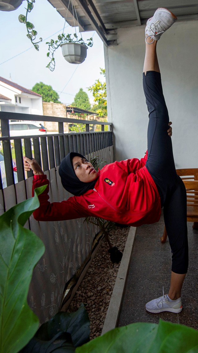 Atlet taekwondo Defia Rosmaniar melakukan perenggangan kaki. Foto: Aditya Pradana Putra/ANTARA FOTO