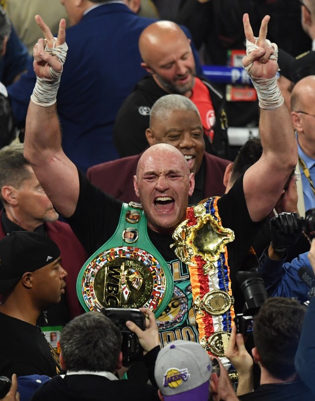 Tyson Fury merayakan kemenangan atas Deontay Wilder. Foto: AFP/Mark Ralston
