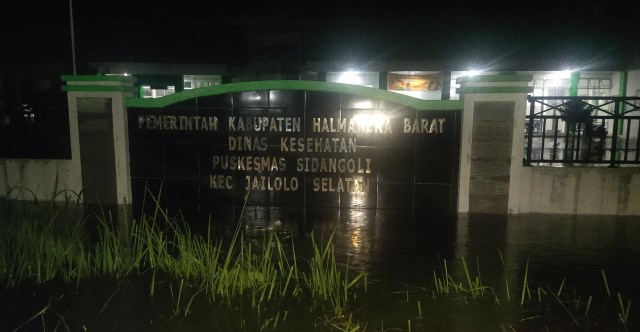 Papan nama Kantor Puskesmas Sidangoli, tergenang air setelah diguyur hujan selama kurang lebih 1 jam. Foto: Zulfikar Saman/cermat