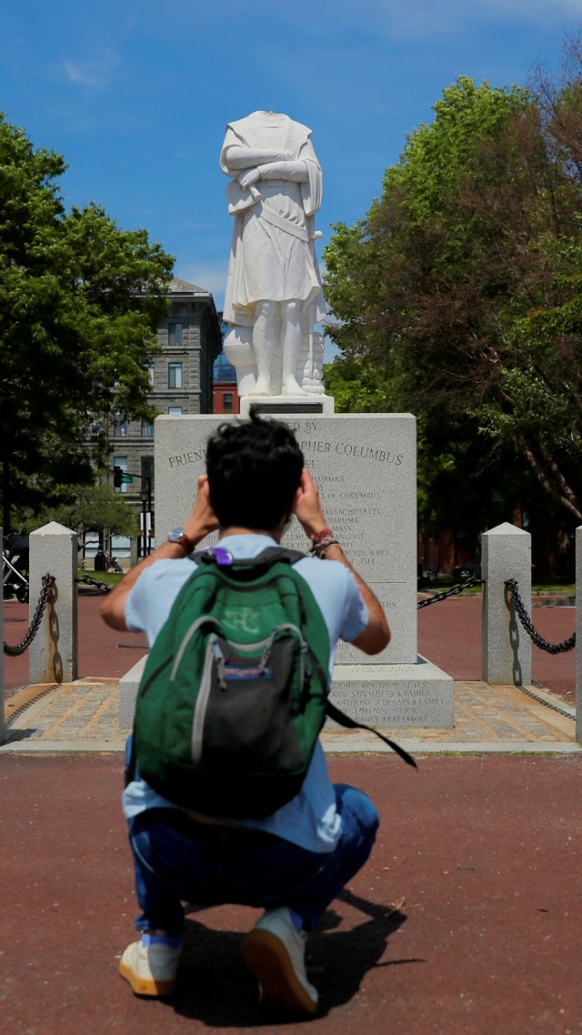 Seorang warga memotret patung Christopher Columbus di Boston, Massachusetts, Amerika Serikat, Rabu (10/6). Foto: Brian Snyder/Reuters